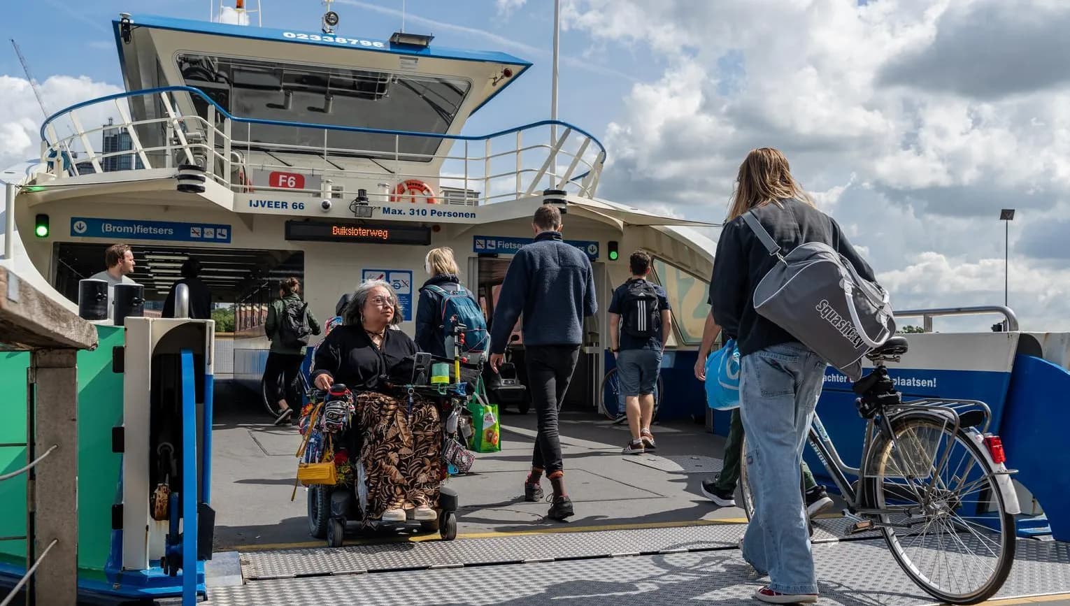 A person in an electric wheelchair exits the ferry.