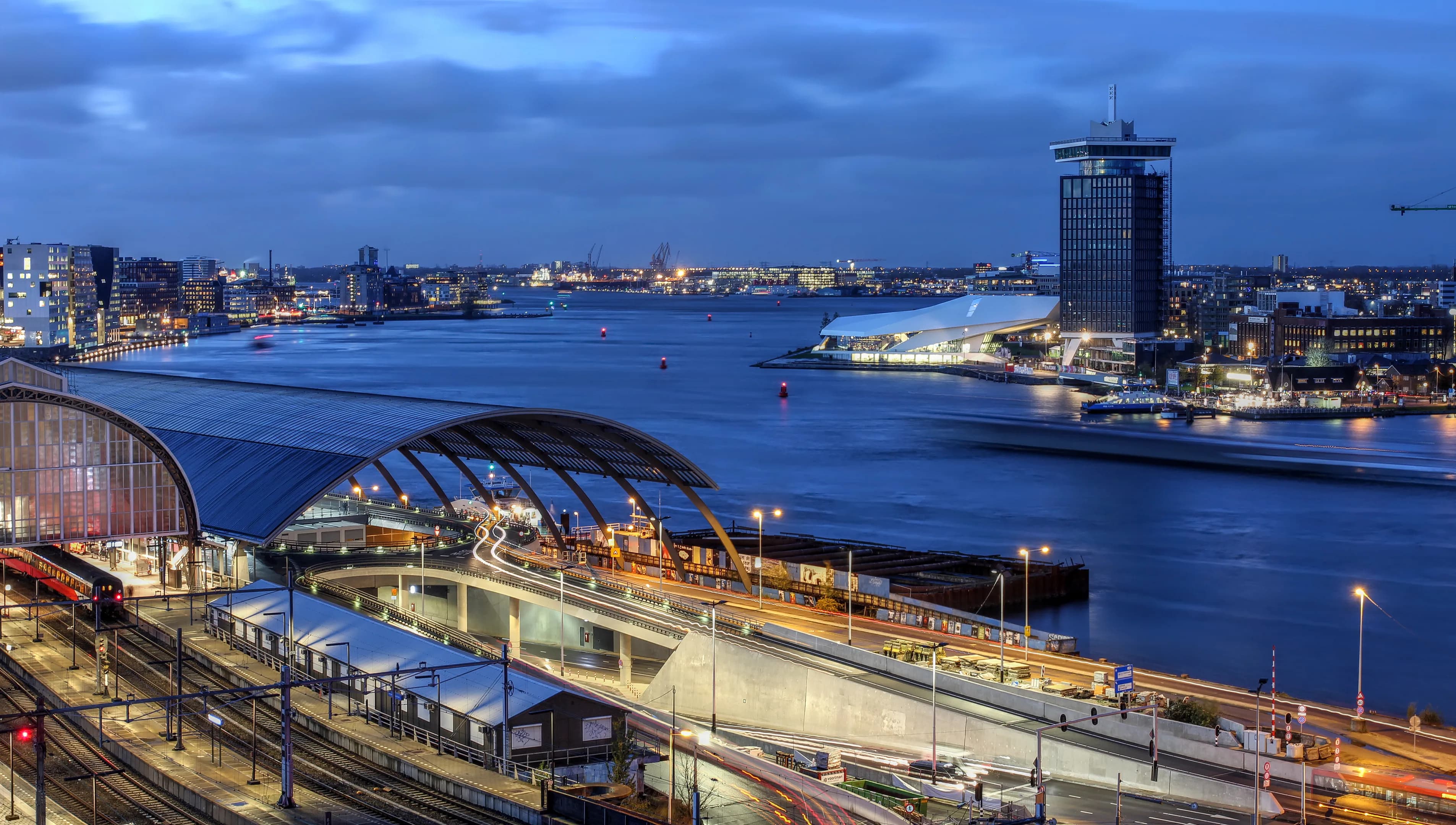 Skyline view of Amsterdam's waterfront facing the Ij River, with A'dam Toren and Amsterdam Eye.