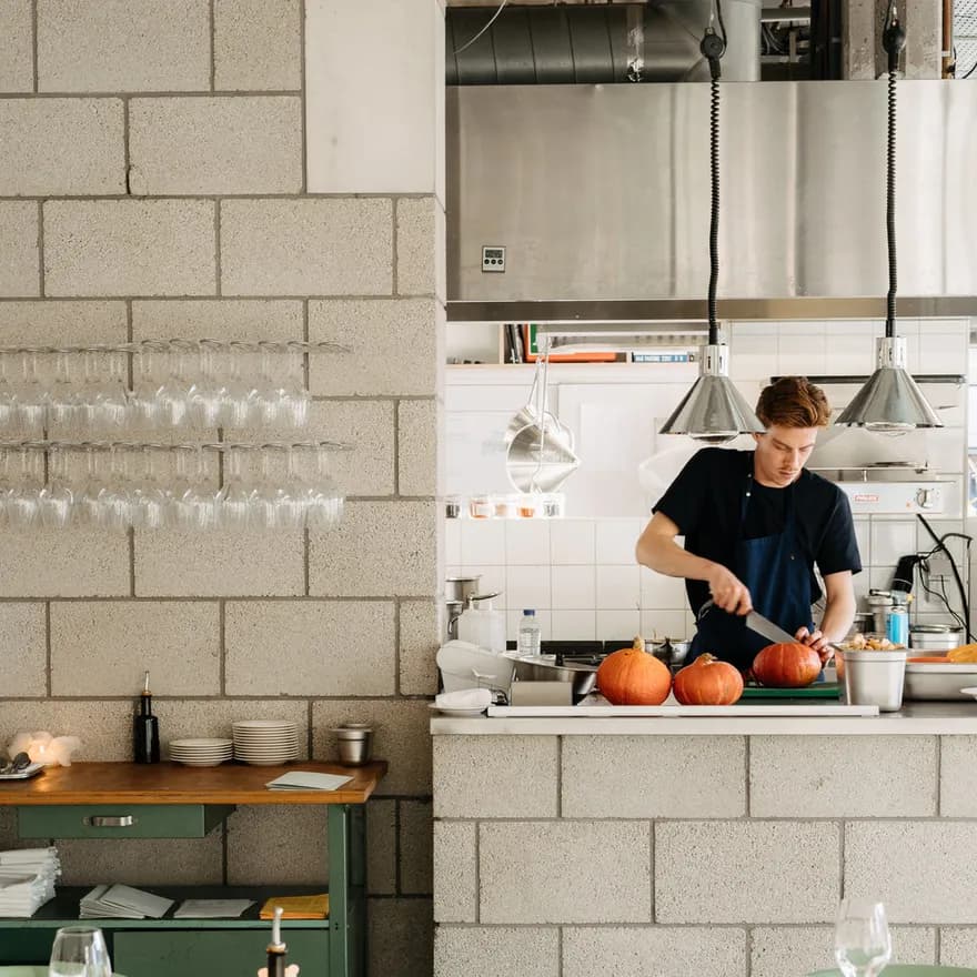 Chef chopping small pumpkin in kitchen at Cafe Restaurant Metro