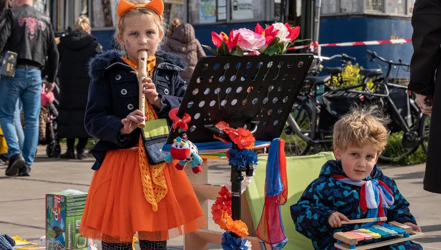 A girl and a boy playing music on King's Day 2023.