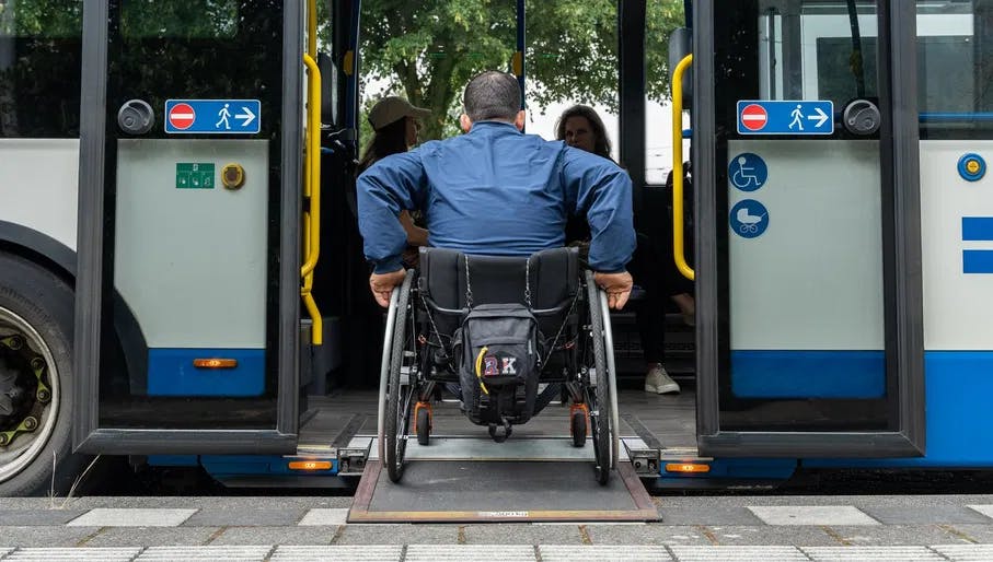 A person in a wheelchair enters the bus.