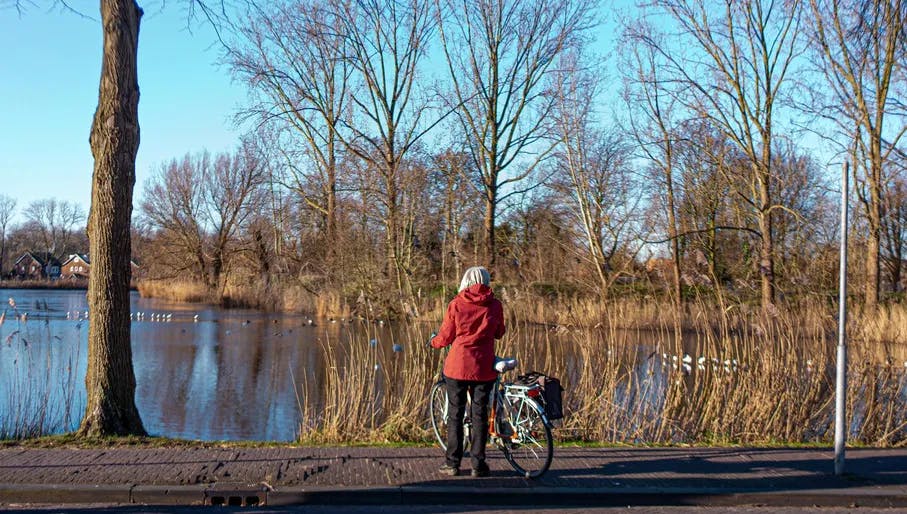 Woman stopped with bike at the River Vecht in Weesp
