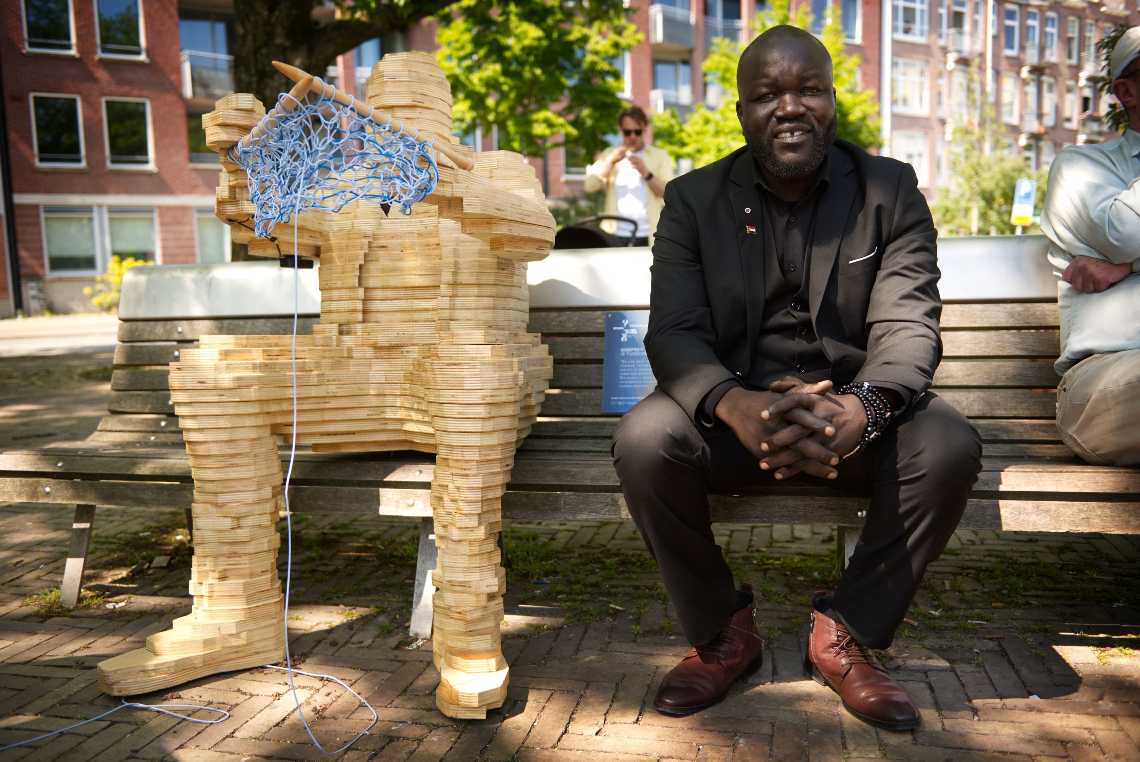 Tussenmens Godfrey bij zijn beeld