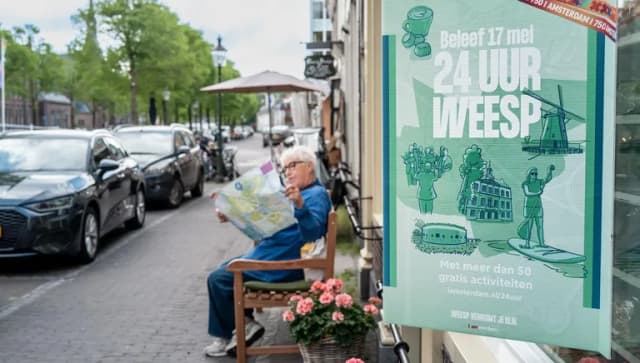 24 uur Weesp Branding, woman on a bench checks the flyer.
