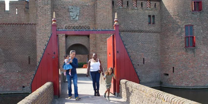 Family walking on The Muiderslot Castle entrance bridge