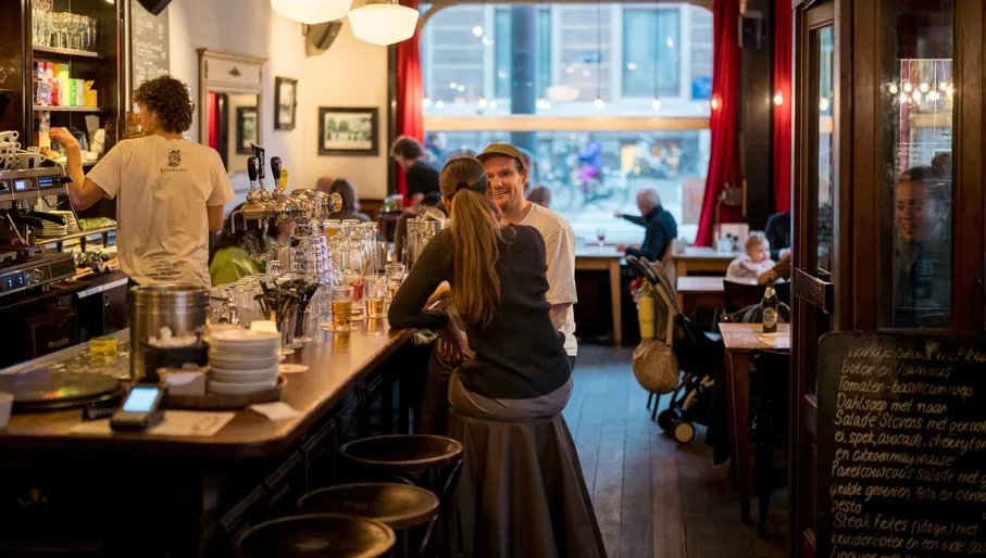 People having drinks at brown bar Café Koosje