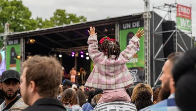 A little girl sitting on her dads shoulders during Keti Koti 2023 at Museumplein.