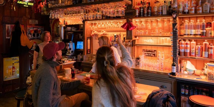 People sitting in brown bar Proeflokaal De Ooievaar