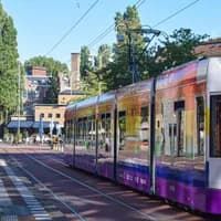 Colourful tram with Pride flag arriving at Javaplein.