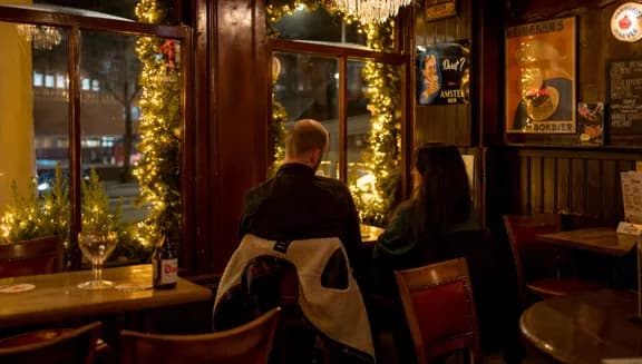 People sitting inside brown bar 't Hooischip by night