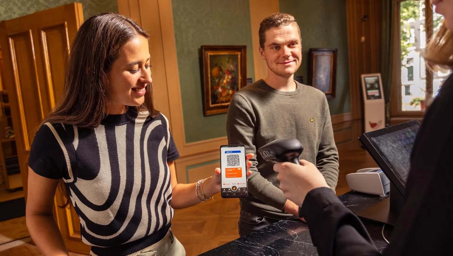 A couple checks-in at the museum desk with the digital City Card app.