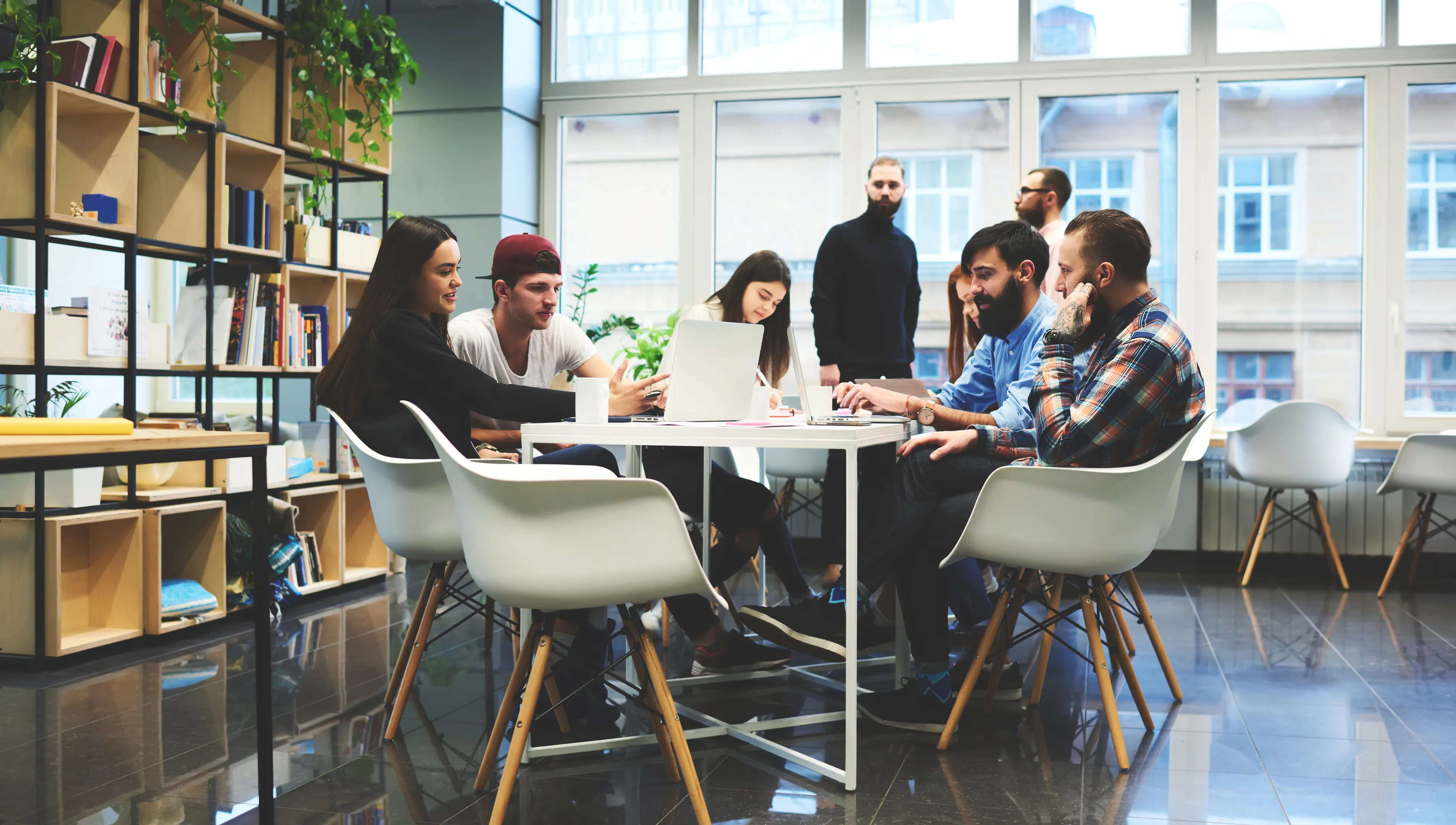 Group of casually dressed businesspeople discussing ideas in the office. Creative professionals gathered at the meeting table for discuss the important issues of the new successful startup project