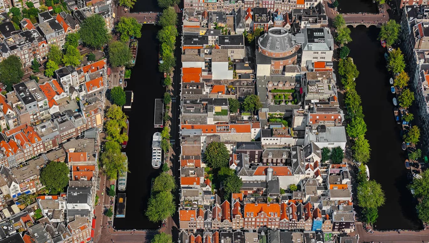 In het stedenbouwkundig concept liggen de grachten bijna evenwijdig aan elkaar. De grachtengordel is een systeem van straten, kades, bruggen en woonhuizen. Veel grachtenpanden zijn van de 18e eeuw en hebben veel verschillende architectuurstijlen. Architect Jacob Otten Husly ontwierp het voormalige kunst en wetenschap centrum aan de Keizersgracht dat in 1788 geopend werd. De grachtengordel West heeft veel historische gebouwen uit de zestiende eeuw en is onderdeel van de binnenstad van Amsterdam. Foto John Gundlach