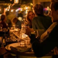 People sitting at the bar at Compartir wine bar and restaurant on Spaarndammerstraat