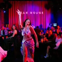 Bar Rouge, interior with drinks and people in the bar, woman giving a show dancing and people smiling