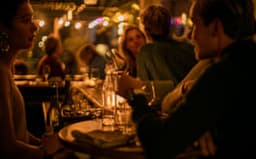 People sitting at the bar at Compartir wine bar and restaurant on Spaarndammerstraat