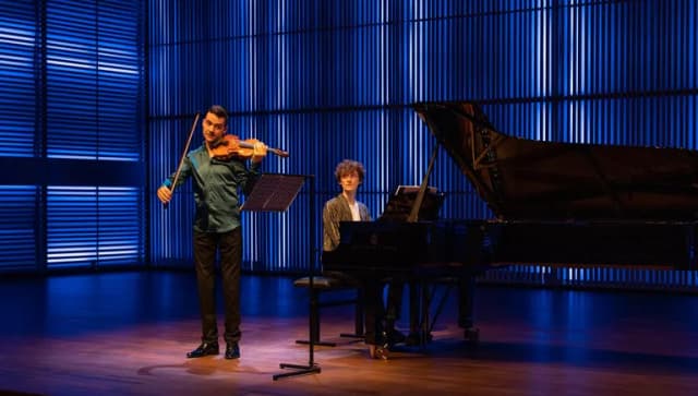 A violinist and a pianist on stage in het Muziekgebouw aan 't IJ