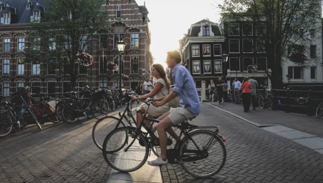 Two people biking through Amsterdam