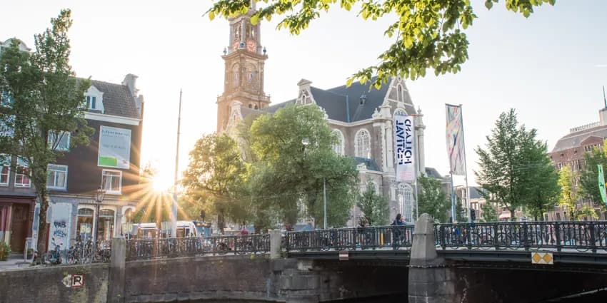 Foto van de Westertoren met brug op de voorgrond.