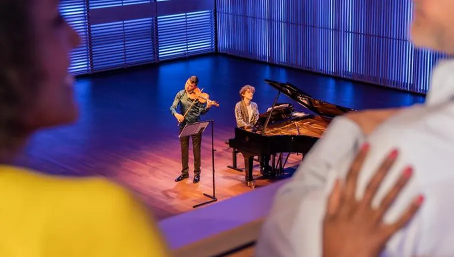 A couple enjoys a concert in het Muziekgebouw aan 't IJ.