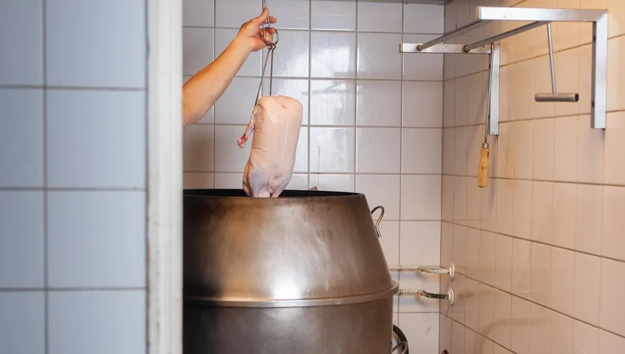 Chef frying duck in the kitchen at New Fusion roti shop Amsterdam