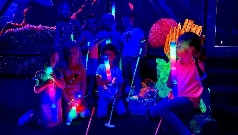 Aloha game center, kids at glow in the dark mini golf
