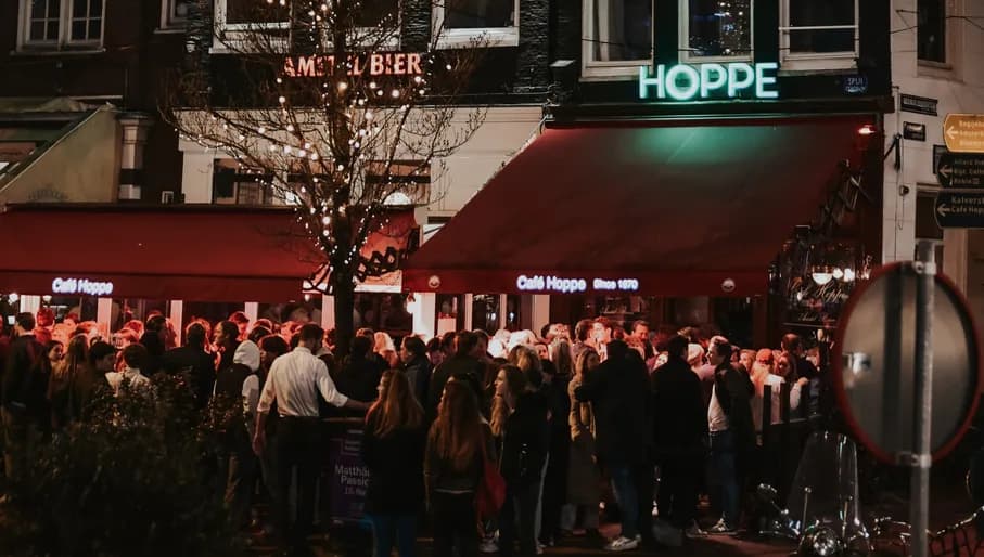 Café Hoppe people standing outside by night
