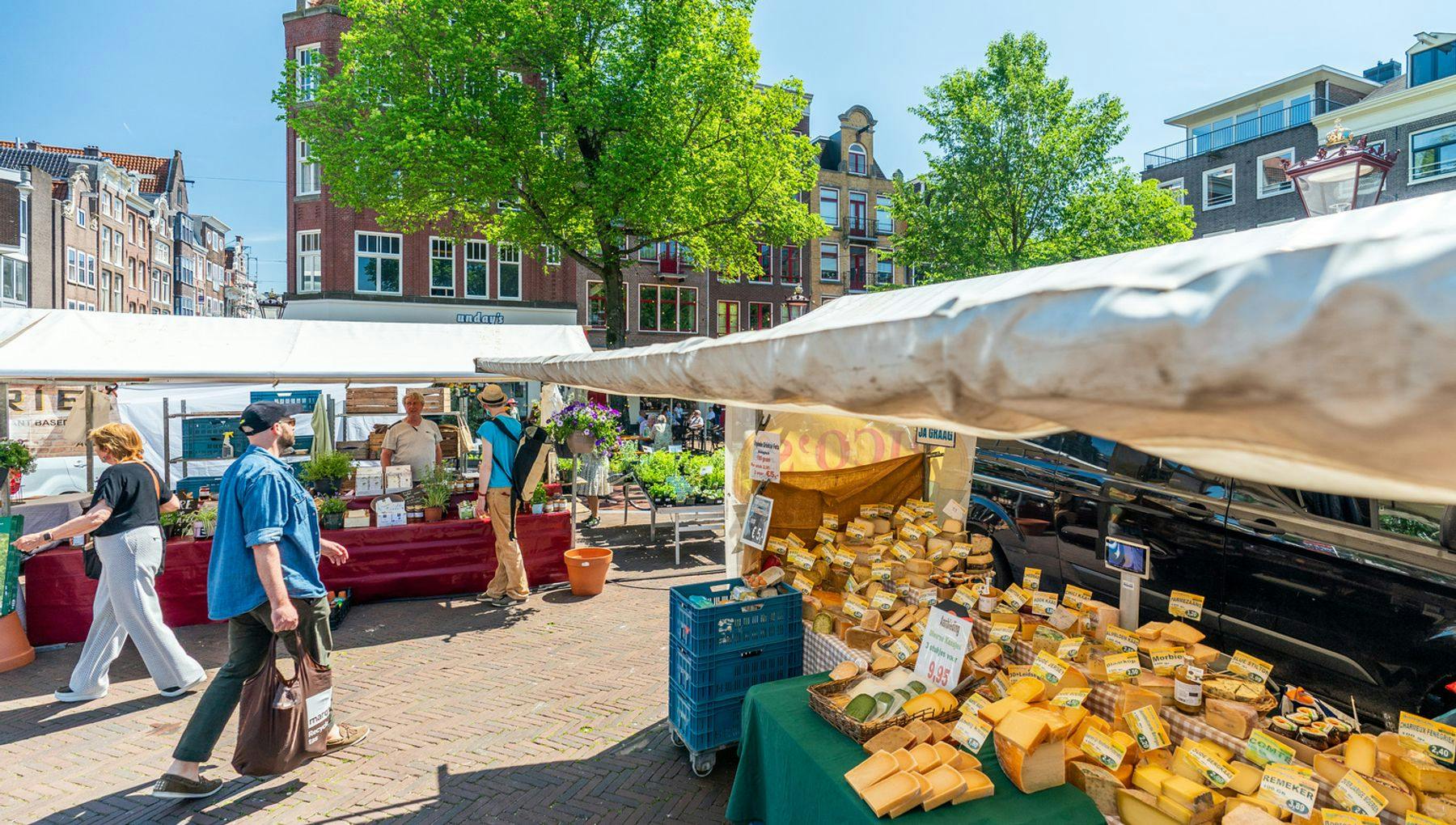 People shopping at the Haarlemmerplein Boerenmarket farmer's market cheese stall