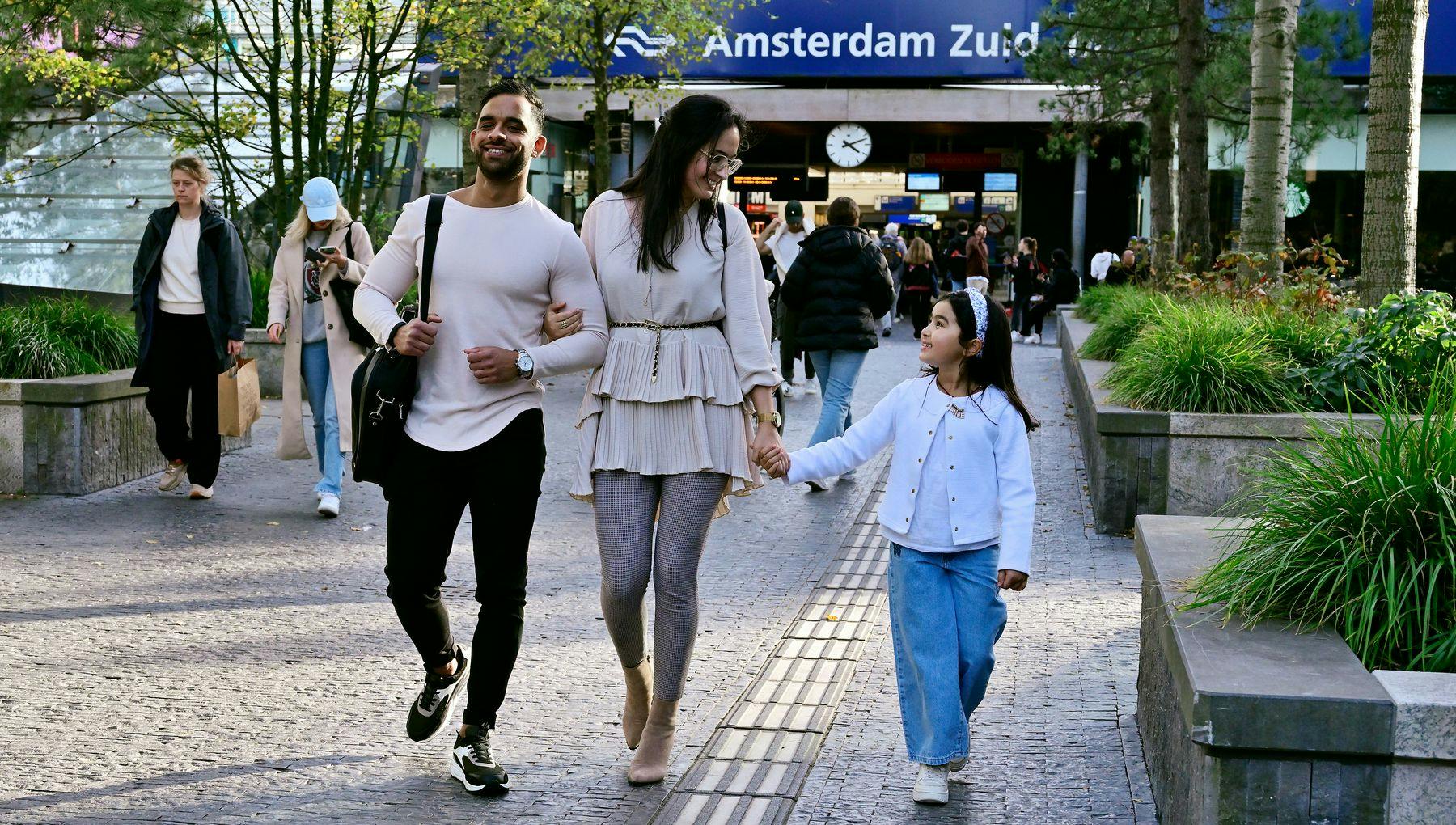 Family walking in front of NS Station Amsterdam Zuid
