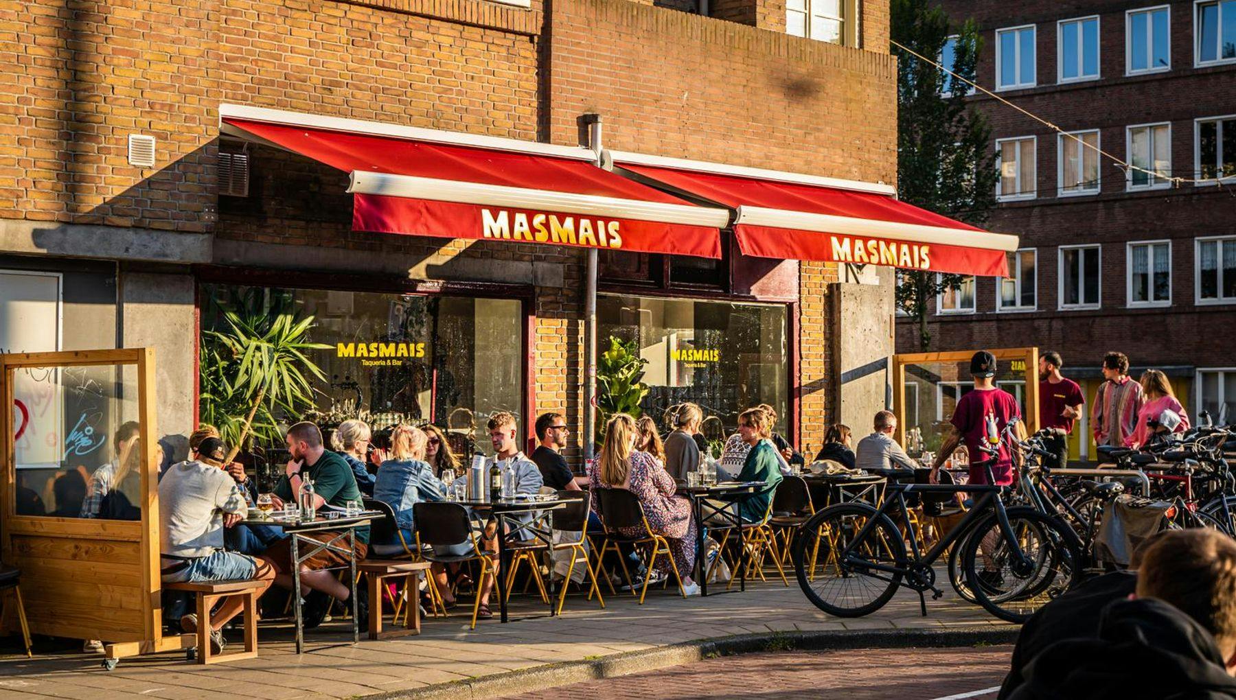People sitting on the terrace of Mexican bar and restaurant Masmais on the Hoofdweg.