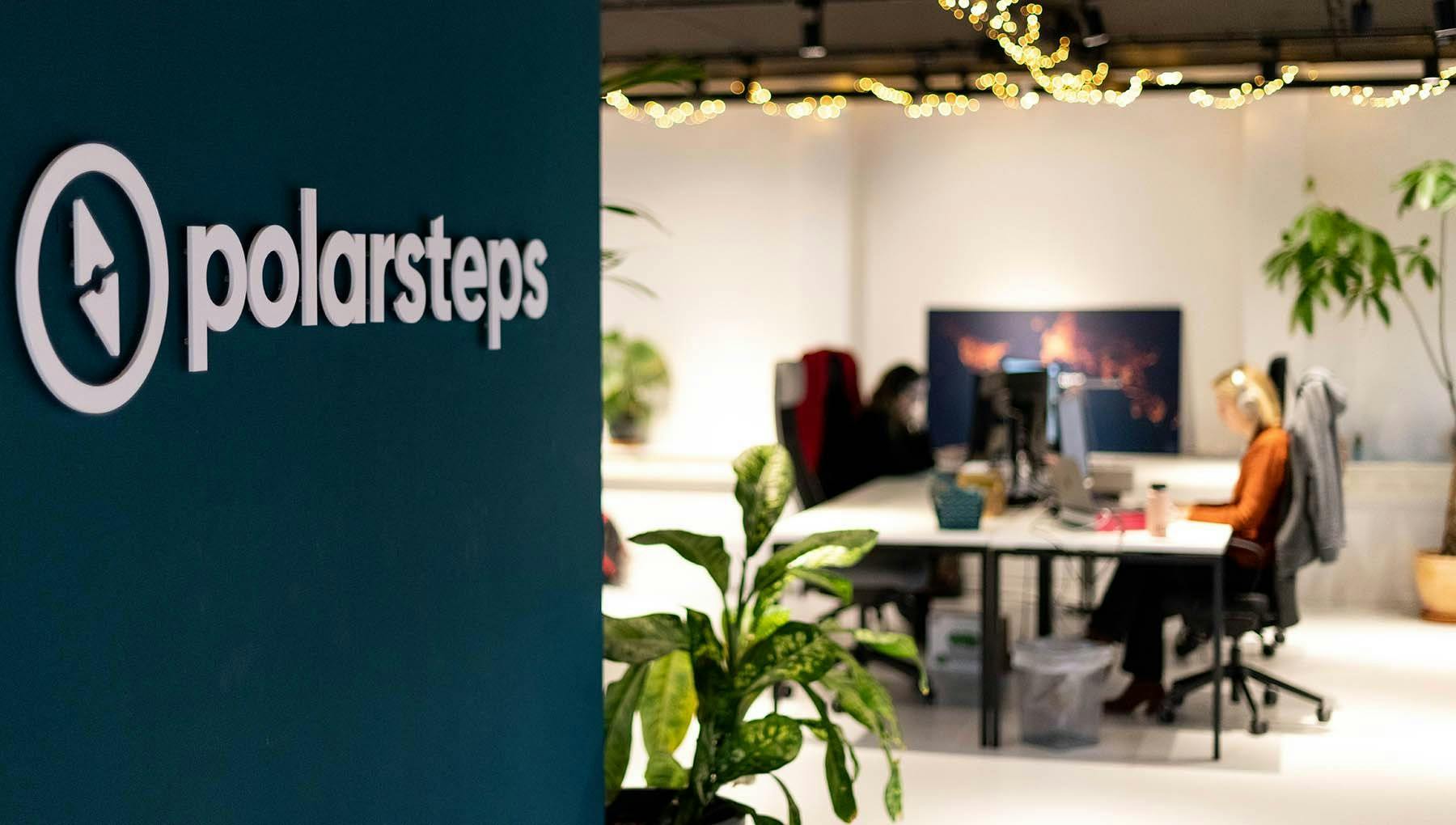 Polarsteps office with logo on the wall and desks in background.
