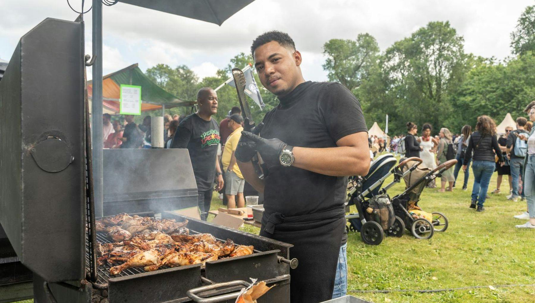 A man grilling chicken on the bbq during Keti Koti Festival 2022 in the Oosterpark.