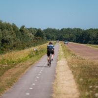 A cyclist on De Knardijk. An inner dike that forms the border between eastern and southern Flevoland as a land divide.