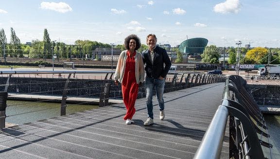 A couple crossing the bridge towards het Muziekgebouw aan 't IJ.