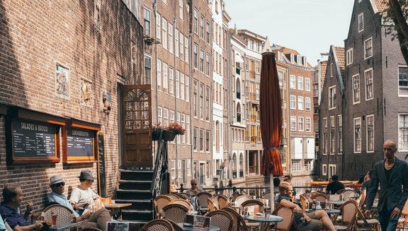 People sitting on the terrace of De Haven van Texel, a restaurant at the Oudezijds Voorburgwal, De Wallen area in the city centre.