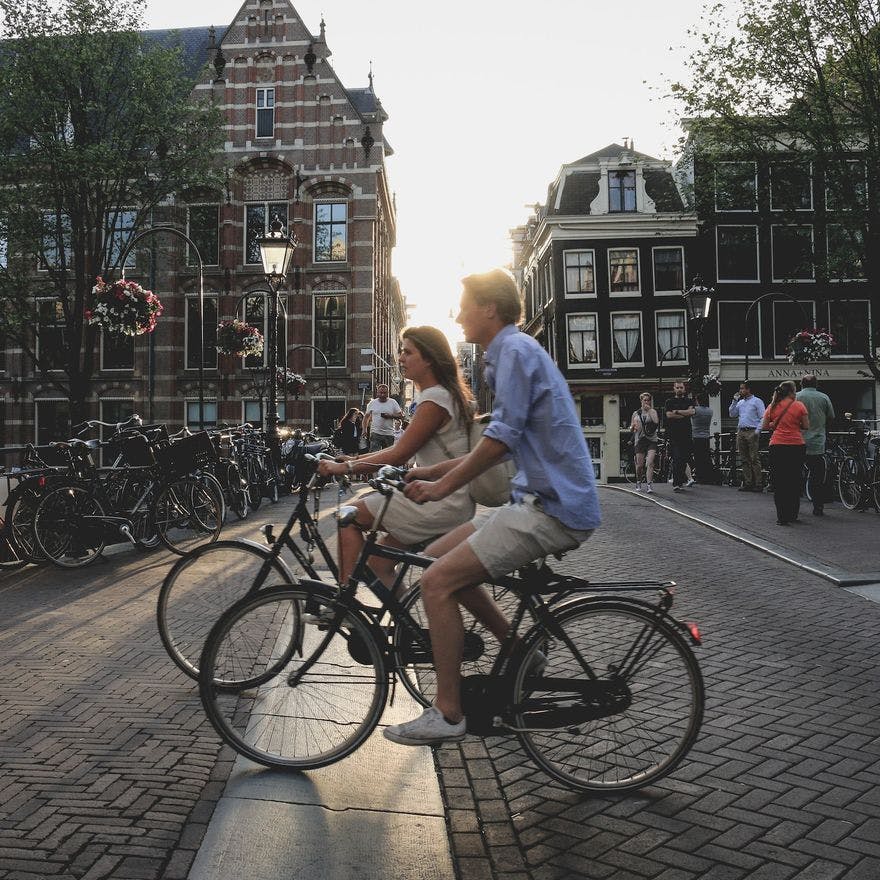 Two people biking through Amsterdam