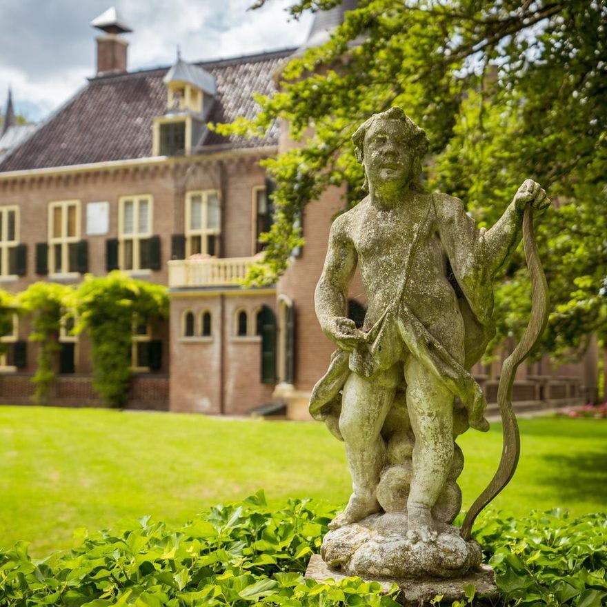 Statue of Cupid in the garden of Keukenhof Castle.