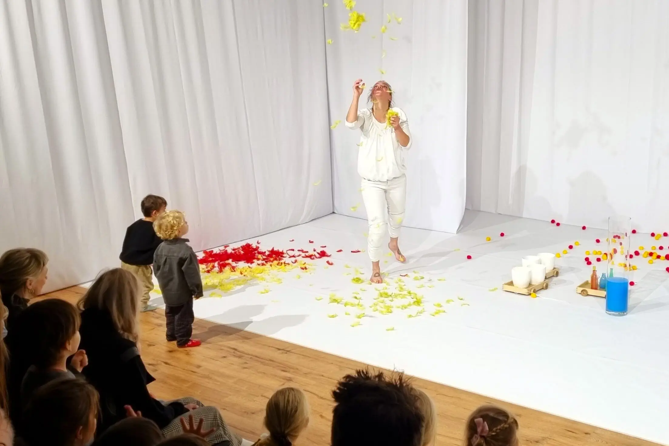 Kinderen kijken aandachtig naar hoe de veertjes door de lucht zweven