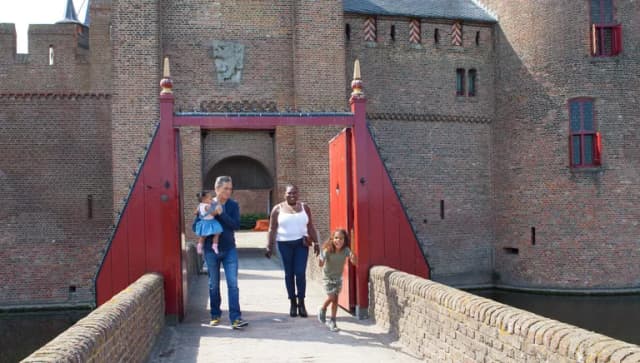 Family walking on The Muiderslot Castle entrance bridge