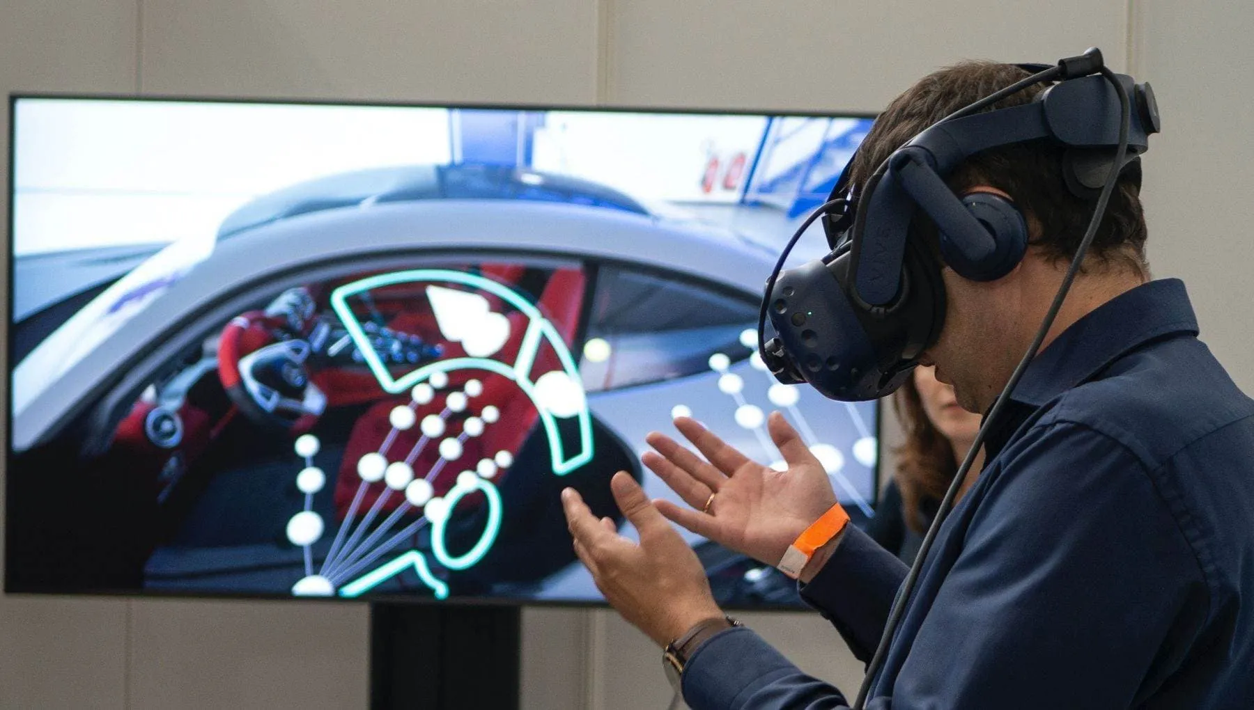 A man wearing a VR headset in front of a screen, apparently during a demonstration at VR Days 2021 conference.