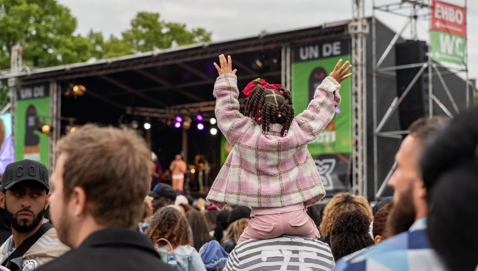 A little girl sitting on her dads shoulders during Keti Koti 2023 at Museumplein.