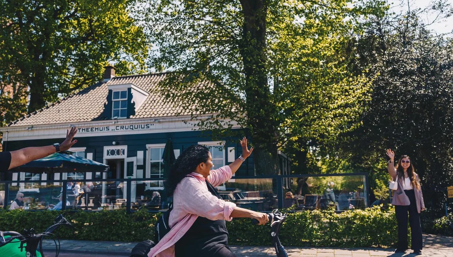 Two women waving goodbye at Theehuis Cruquius.