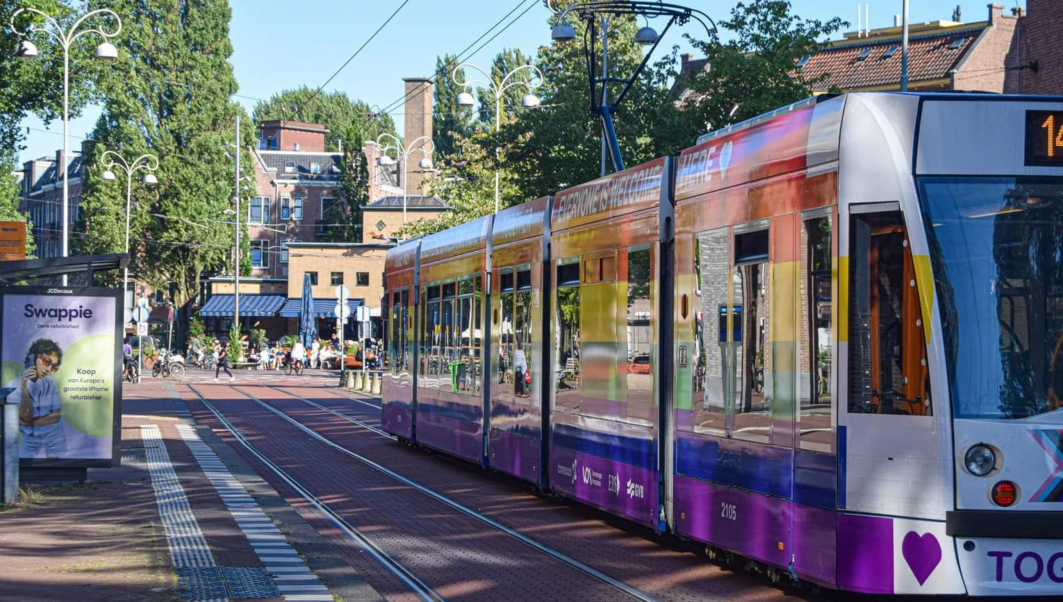 Colourful tram with Pride flag arriving at Javaplein.