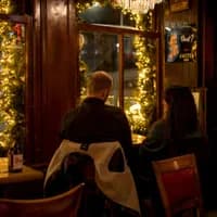 People sitting inside brown bar 't Hooischip by night
