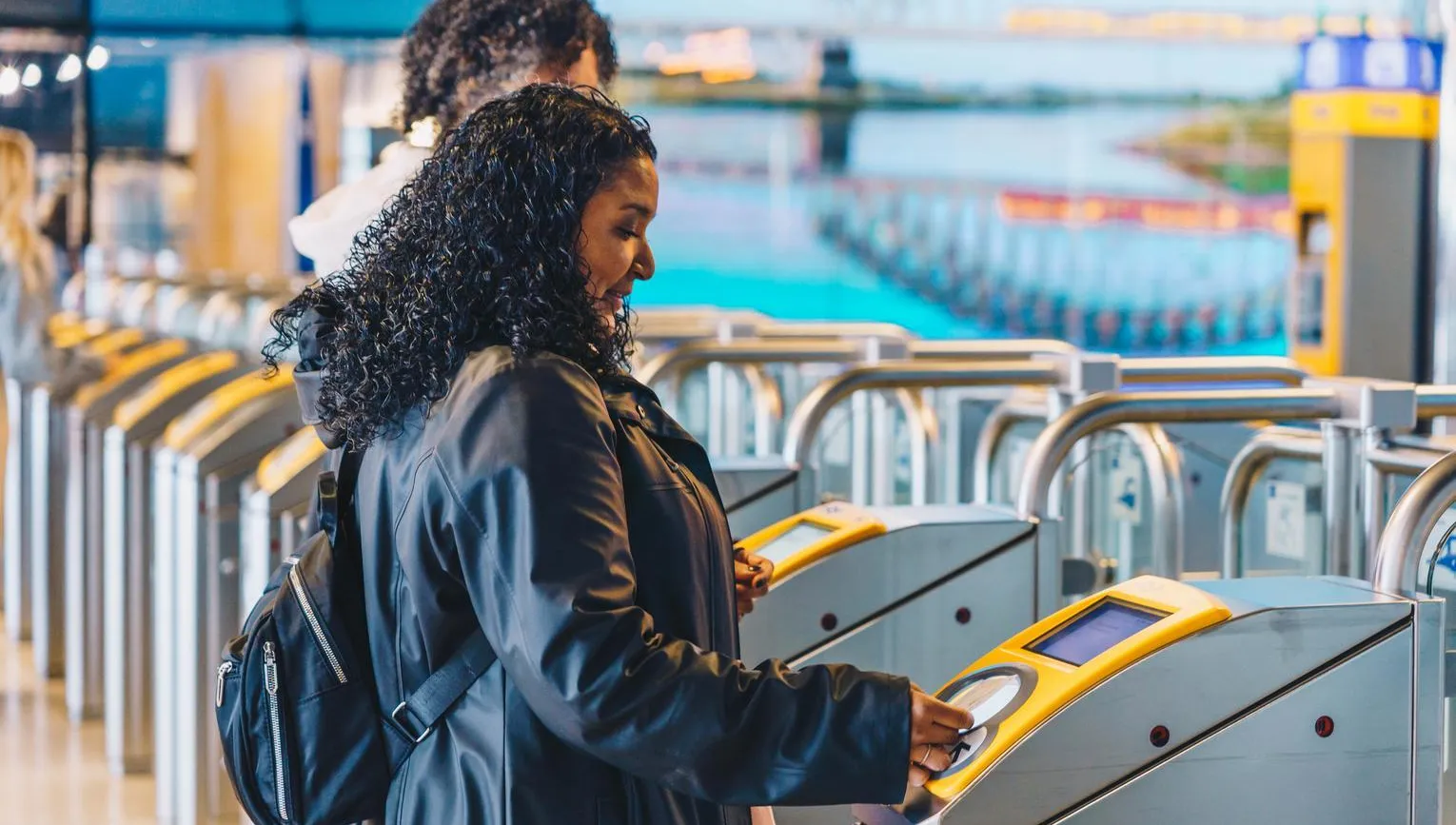 A woman goes through the public transport gates at Amsterdam Central Train station.