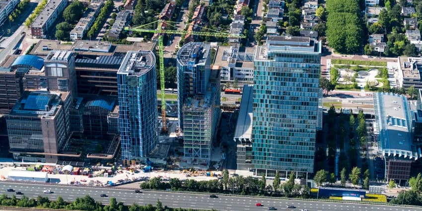 13 July 2020, Amsterdam, Holland. Aerial view of construction site of new skyscraper apartment complex 2AMSTERDAM next to Atrium at the Amsterdam Zuidas