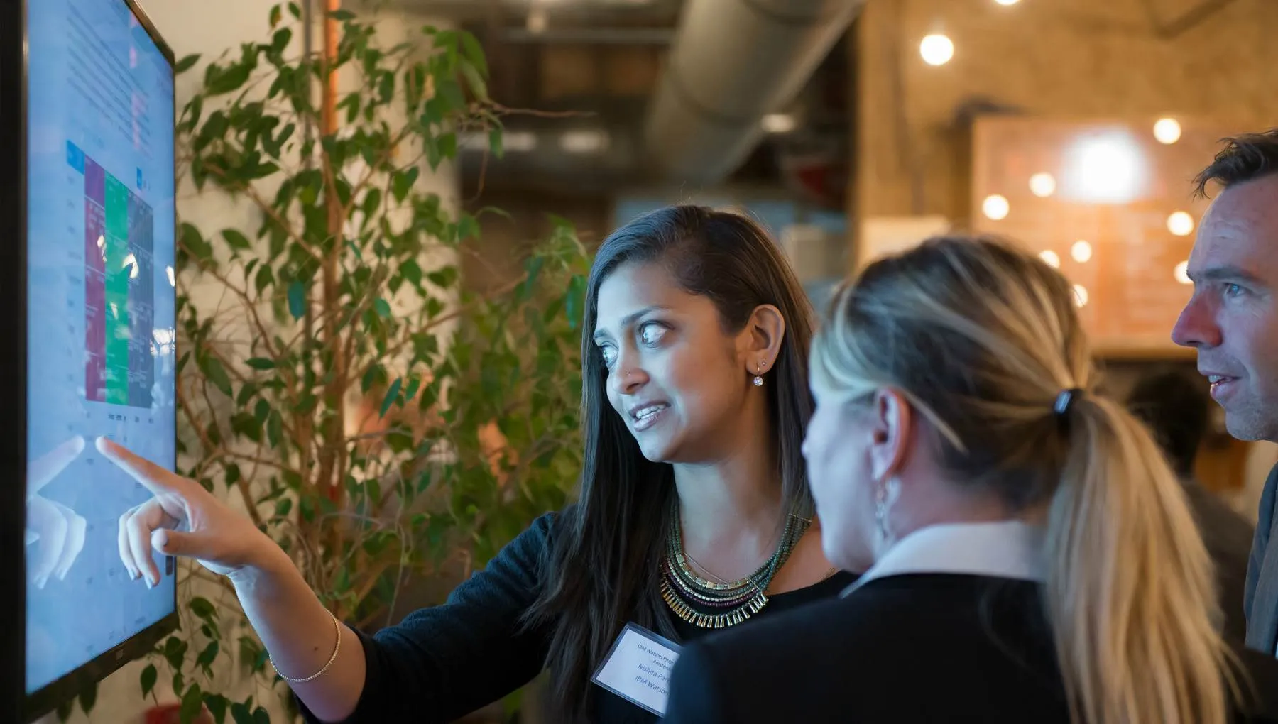 Business woman pointing at presentation screen with colleagues