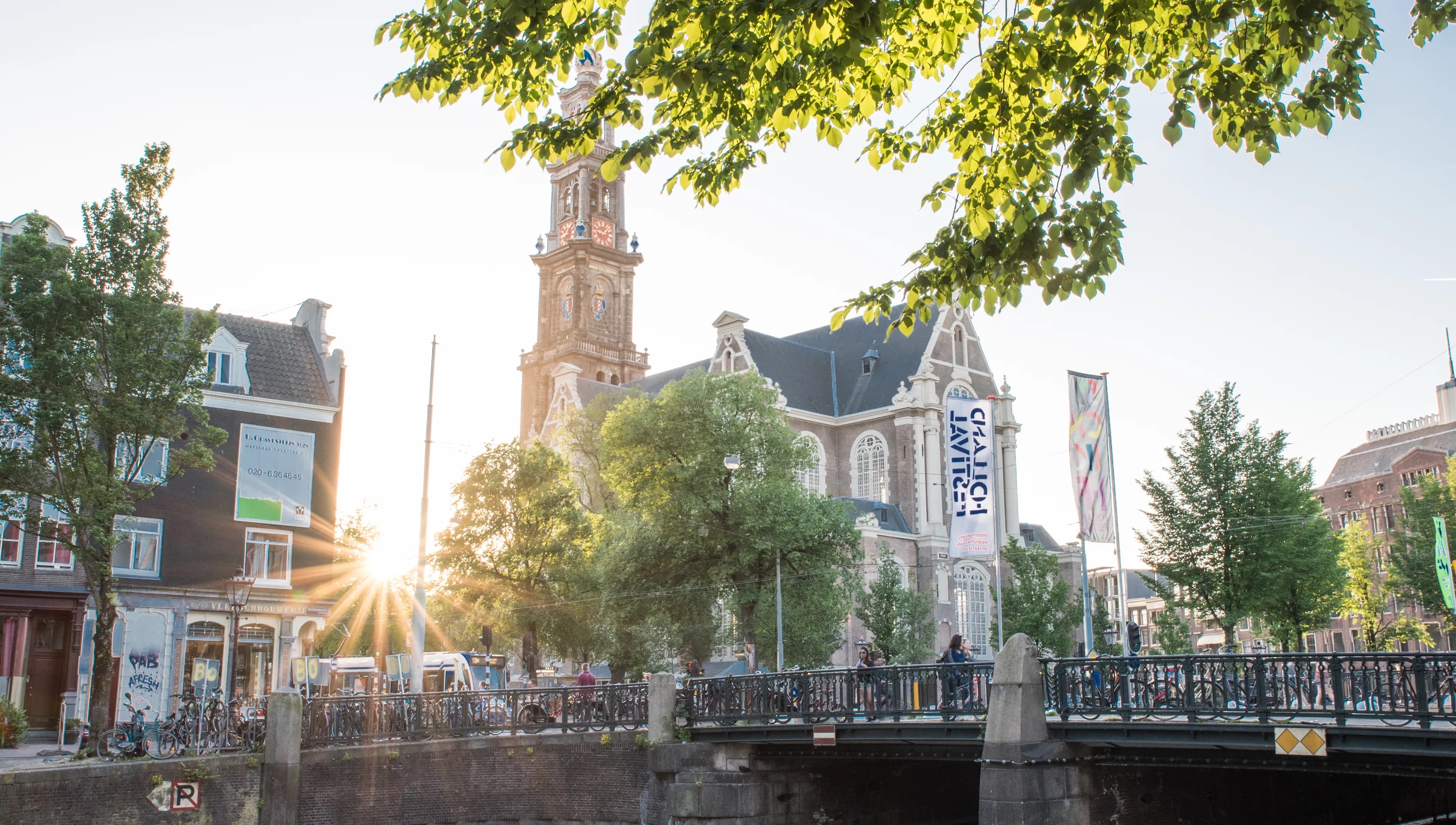 Foto van de Westertoren met brug op de voorgrond.