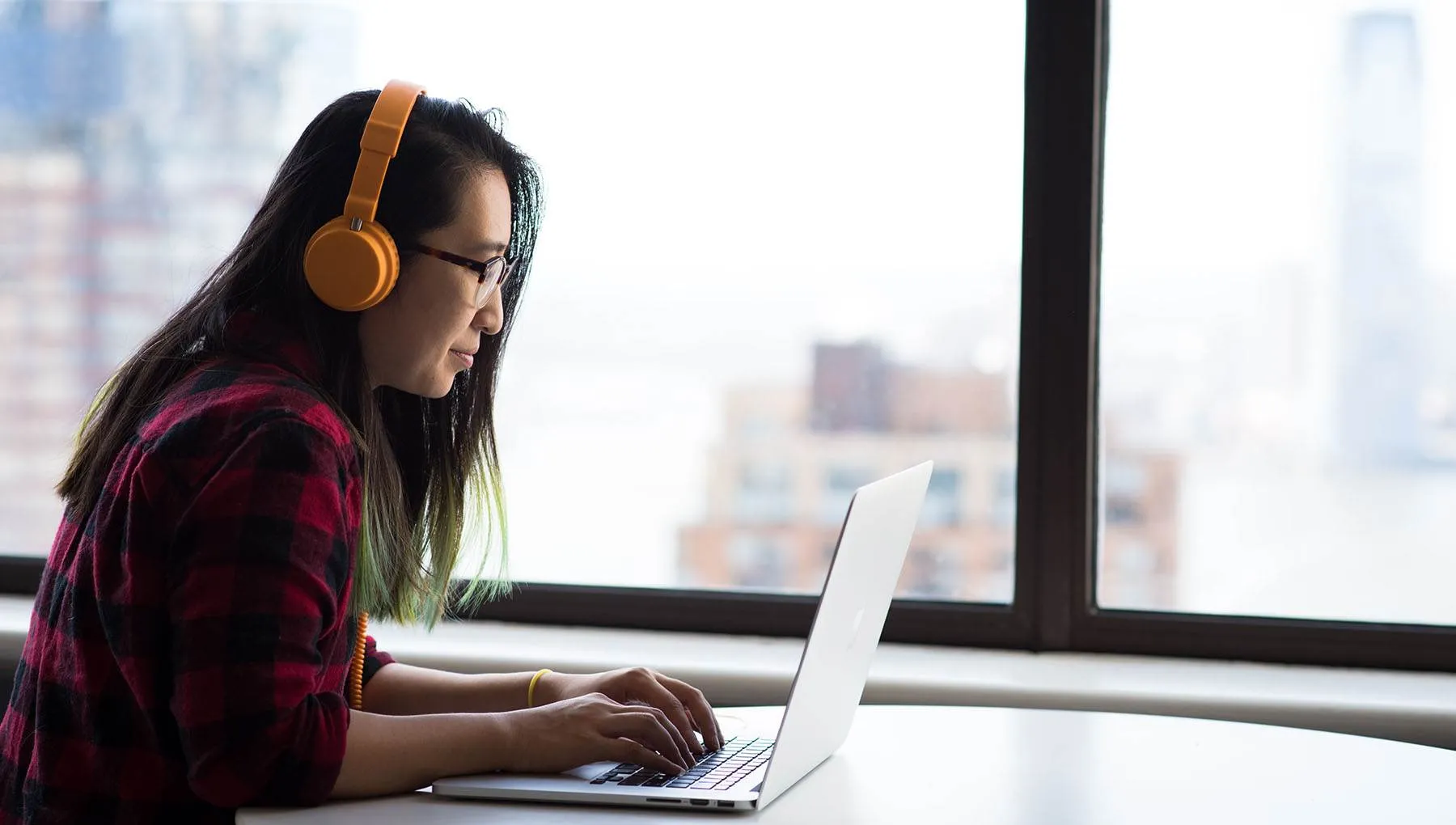 Woman working on laptop in high-rise building