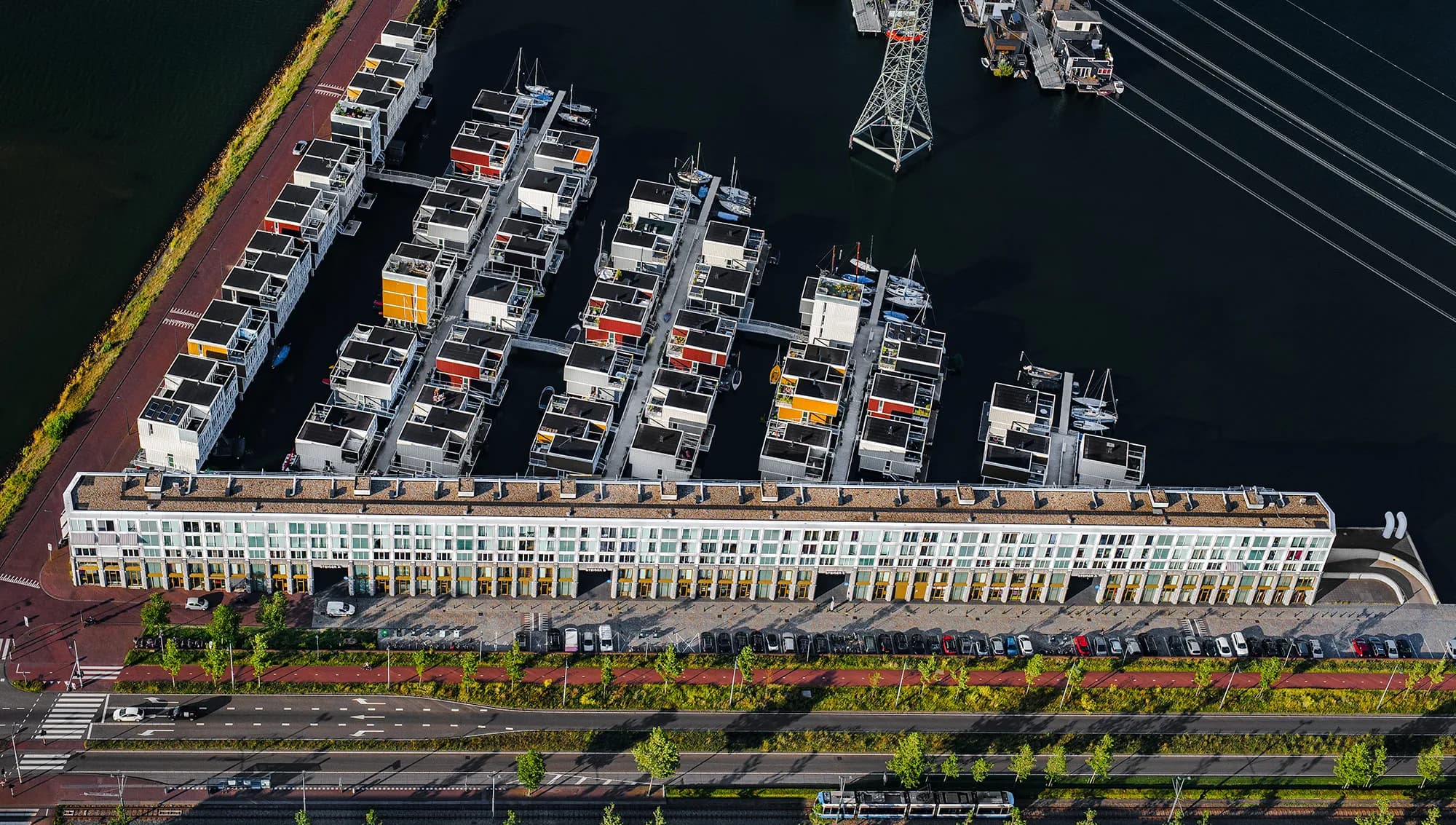 De 75 woningen in de drijvende woonwijk zijn ontworpen door architect Marlies Rohmer en gerealiseerd door ABC Arkenbouw en Koning Bouw. De wijk heeft aanmeerplekken voor bootjes, steegjes en bruggetjes. De vrijstaande koophuizen drijven in Waterbuurt-West; een buurt met een hoge dichtheid. Op een werf in Urk zijn de woningen gebouwd en vervolgens ter plekke geïnstalleerd. De woningen zijn verankerd aan twee meerpalen en daardoor verbonden met de waterbodem. De waterwoningen zijn in 2011 opgeleverd. Foto John Gundlach.